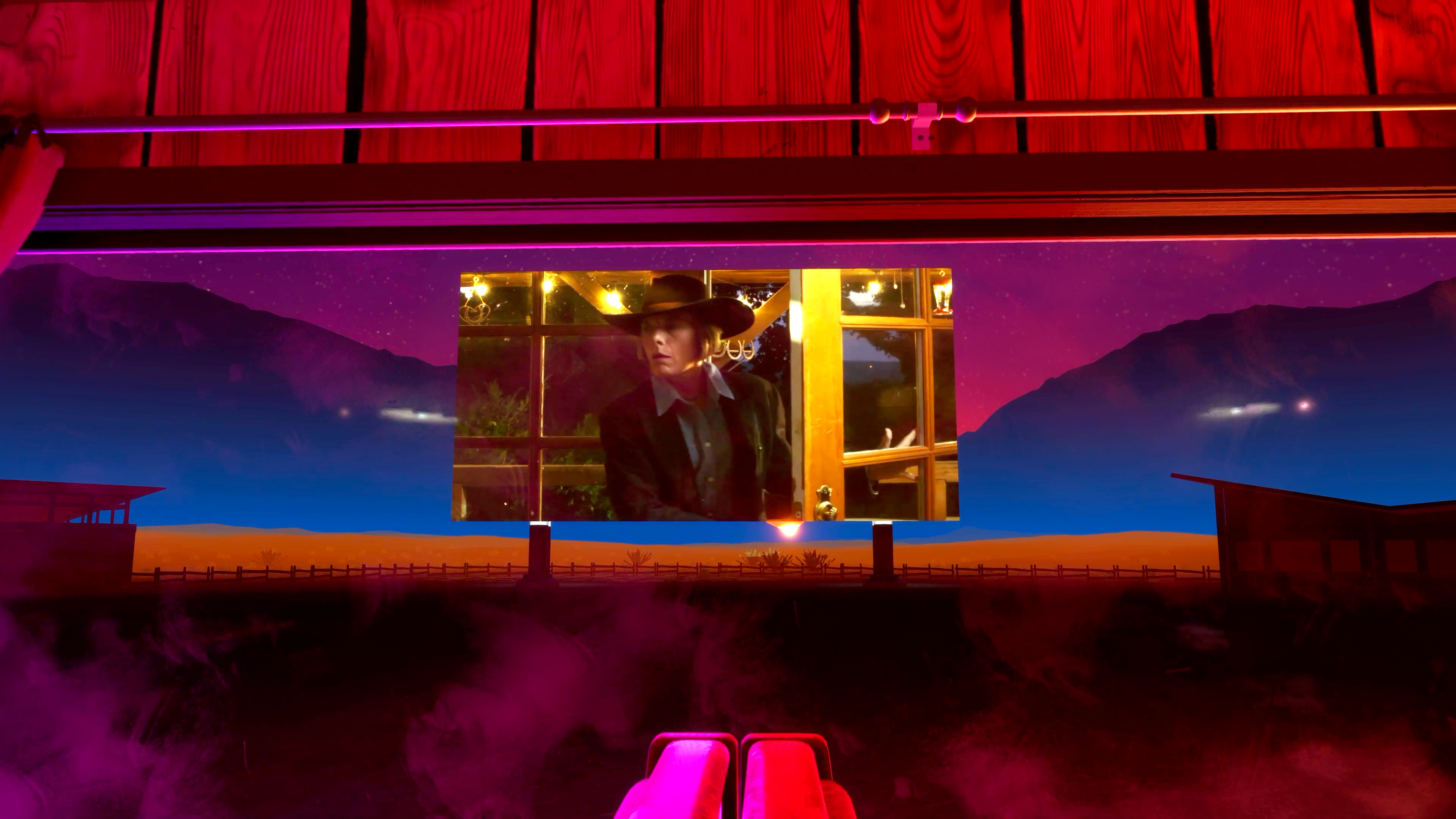 A screenshot showing a drive-in theatre screen with a still of a woman walking into a building.